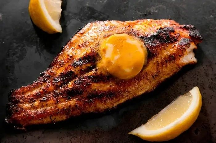Seared fish fillet with golden crust and lemon